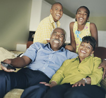 image of smiling family watching tv
