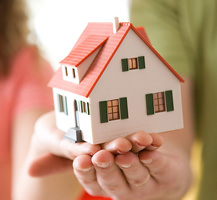 image of hands holding model house