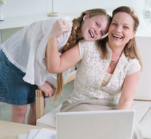 image of smiling mom and daughter with laptop